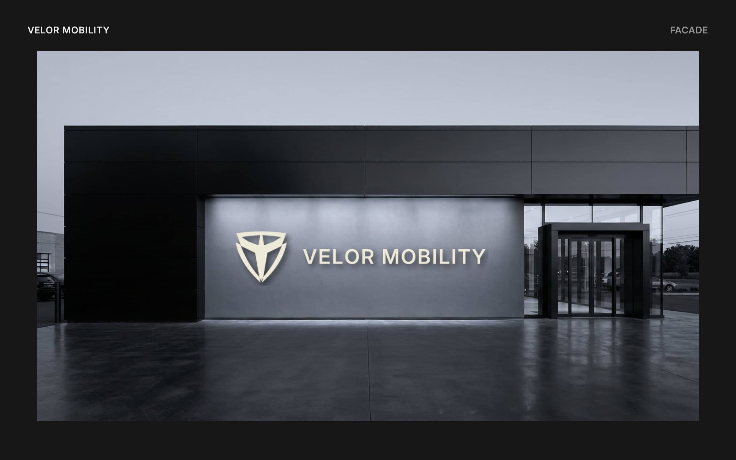 Mockup of a dark showroom facade with the Velor emblem and wordmark in bone letters on a lit grey wall